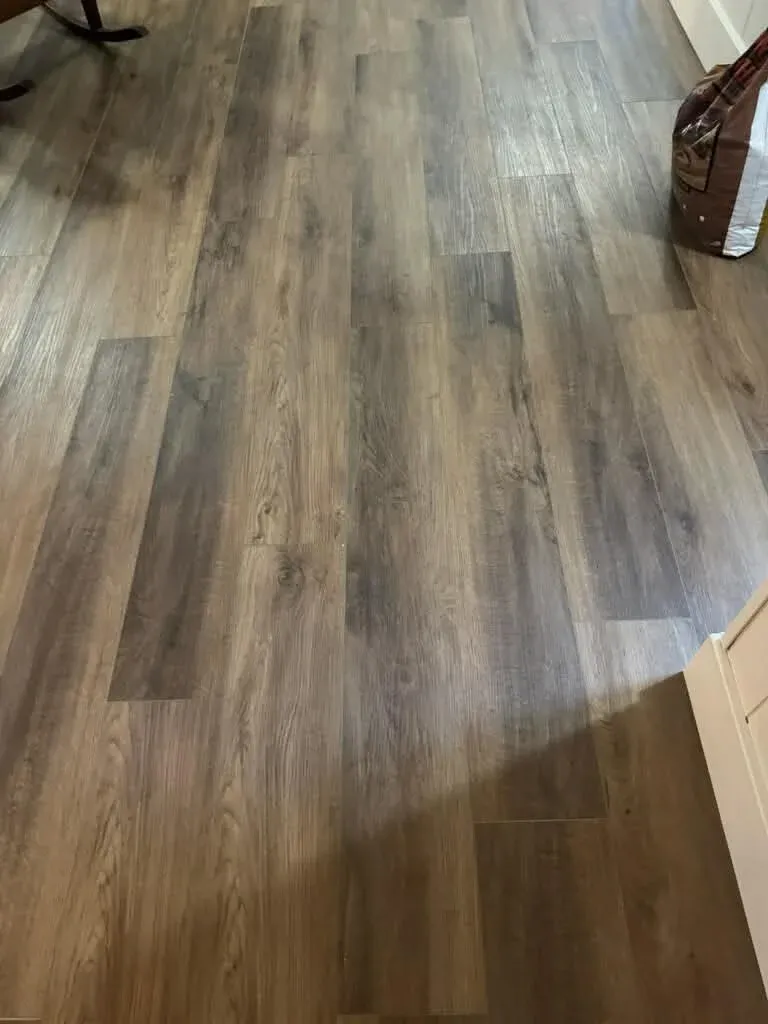 Gray-brown wood-look luxury vinyl plank flooring installed across a room